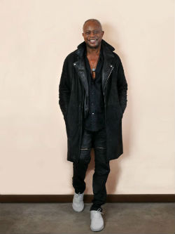 David Sancious standing against wall in leather jacket